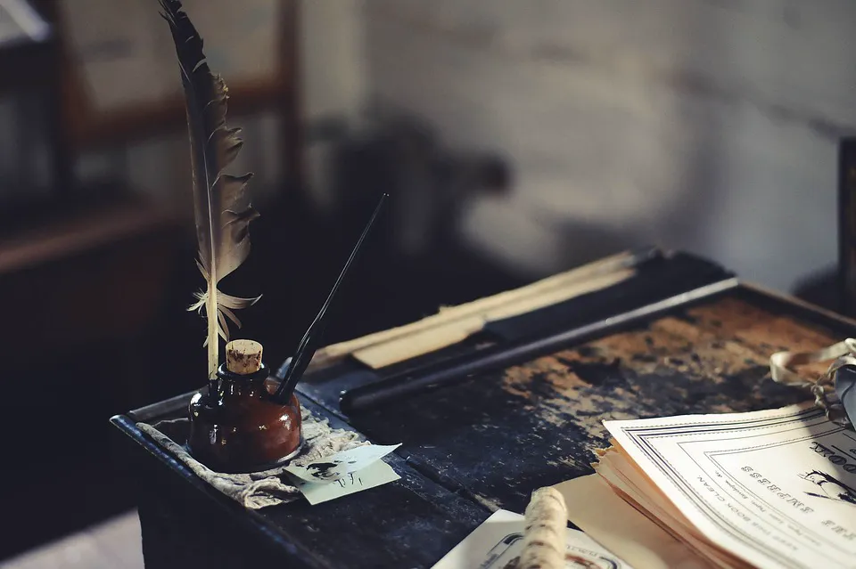 Quill and inkwell on an old desk