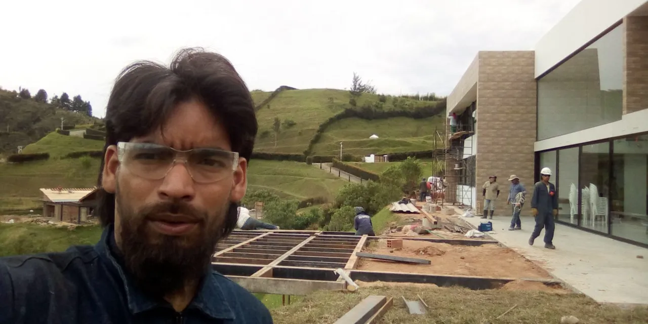 Mateo Uribe González in front of a house under construction
