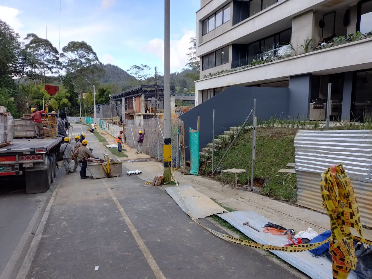 Street works with workers, a truck, and a building in the background