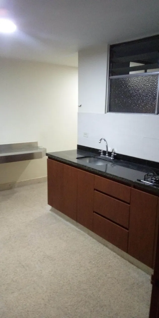 Kitchen finished with wooden cabinets and dark countertops